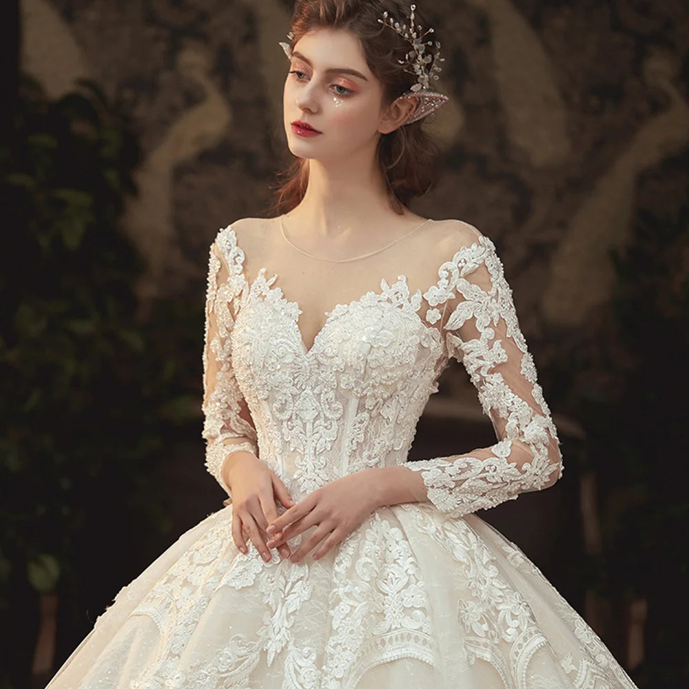Robe de mariée en dentelle, perles et manches longues – CLEVI Paris